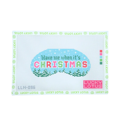 A Lucky Lotus needlepoint canvas featuring a festive Christmas design. The design shows a light blue oval with the text 'Wake me when it's CHRISTMAS' in colorful pixelated letters, set against a snowy landscape with green pine trees.