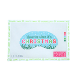 A Lucky Lotus needlepoint canvas featuring a festive Christmas design. The design shows a light blue oval with the text 'Wake me when it's CHRISTMAS' in colorful pixelated letters, set against a snowy landscape with green pine trees.
