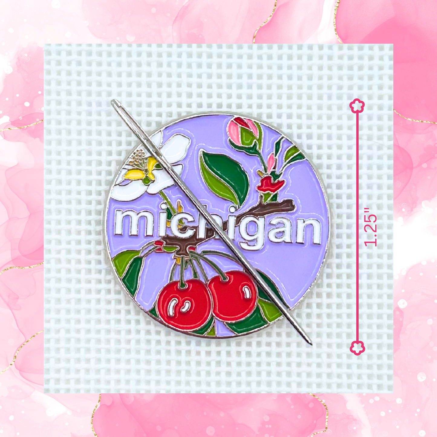 Michigan state needlepoint needle minder close up featuring cherries, apple blossom, greenery, and a needle on a purple background.