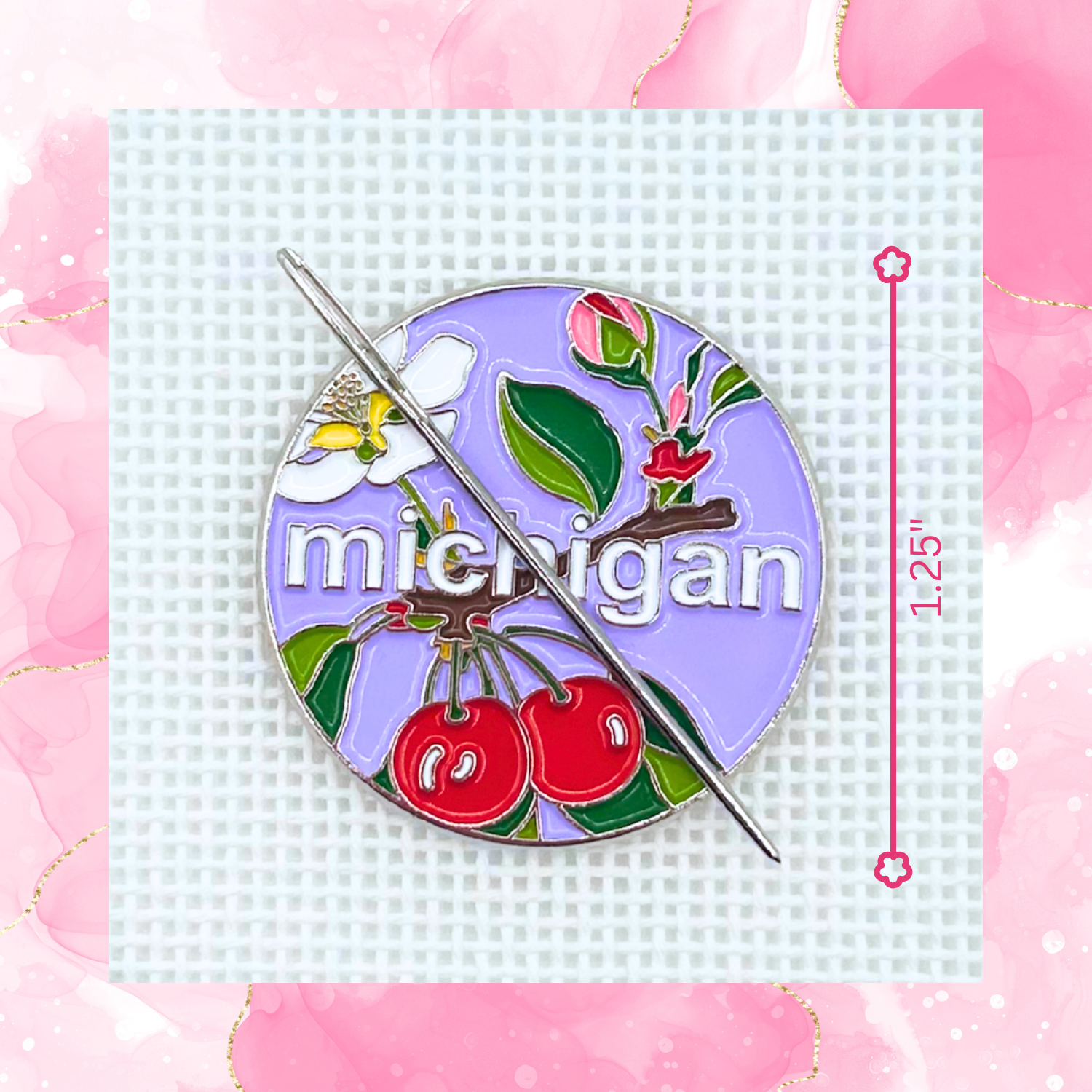 Michigan state needlepoint needle minder close up featuring cherries, apple blossom, greenery, and a needle on a purple background.