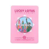 New York needle minder featuring the Statue of Liberty, colorful NYC skyline, and New York lettering on Lucky Lotus Needlepoint packaging