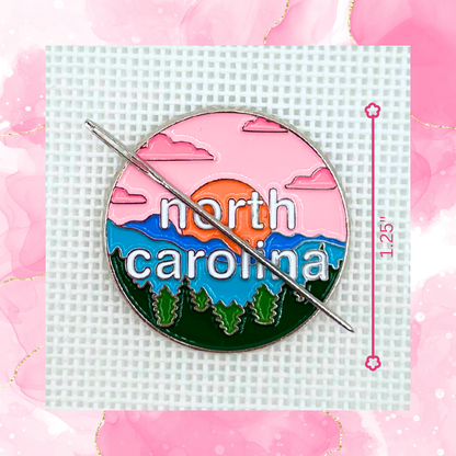 North Carolina needlepoint needle minder close up featuring mountains, pine trees and a colorful sunset design.