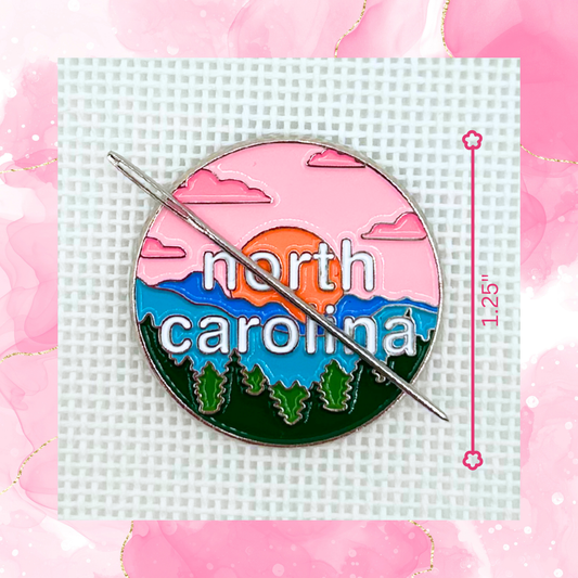 North Carolina needlepoint needle minder close up featuring mountains, pine trees and a colorful sunset design.