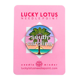 South Carolina needle minder featuring a palmetto tree against a colorful coastal sunset with South Carolina lettering.