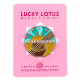 Tennessee needle minder featuring an acoustic guitar, colorful wildflowers, turquoise background, and Tennessee lettering.