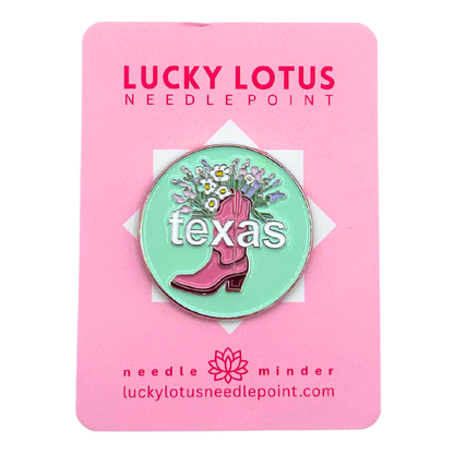 Texas needle minder featuring a pink cowboy boot filled with colorful wildflowers on a mint green background with Texas lettering.