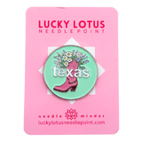 Texas needle minder featuring a pink cowboy boot filled with colorful wildflowers on a mint green background with Texas lettering.